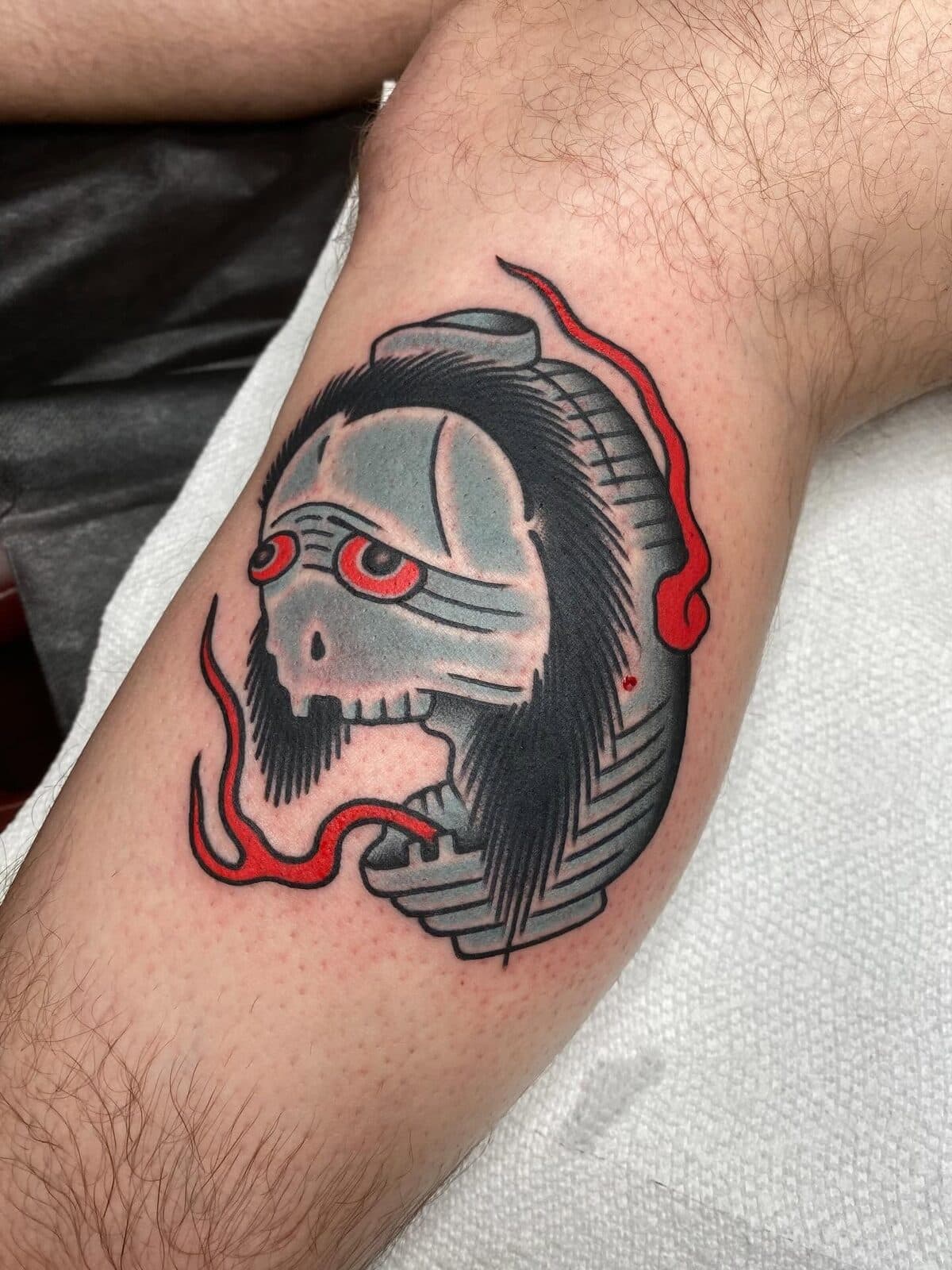 Traditional skull tattoo with red smoke accents