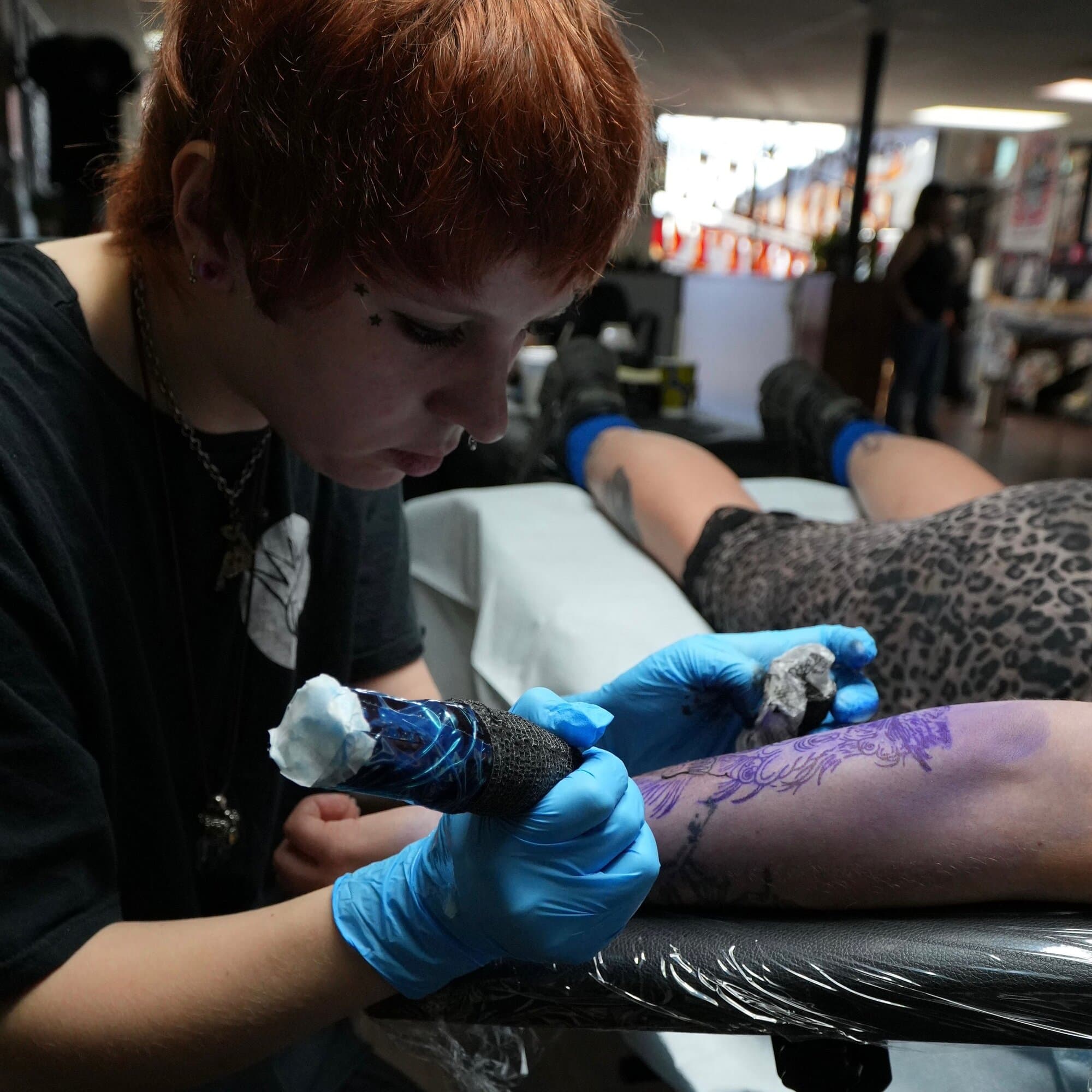 Ava Brady tattooing a client at a tattoo convention