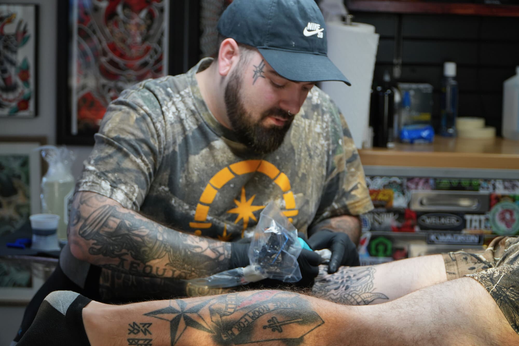 Mike Horman tattooing a client's leg at Red Letter Tattoo