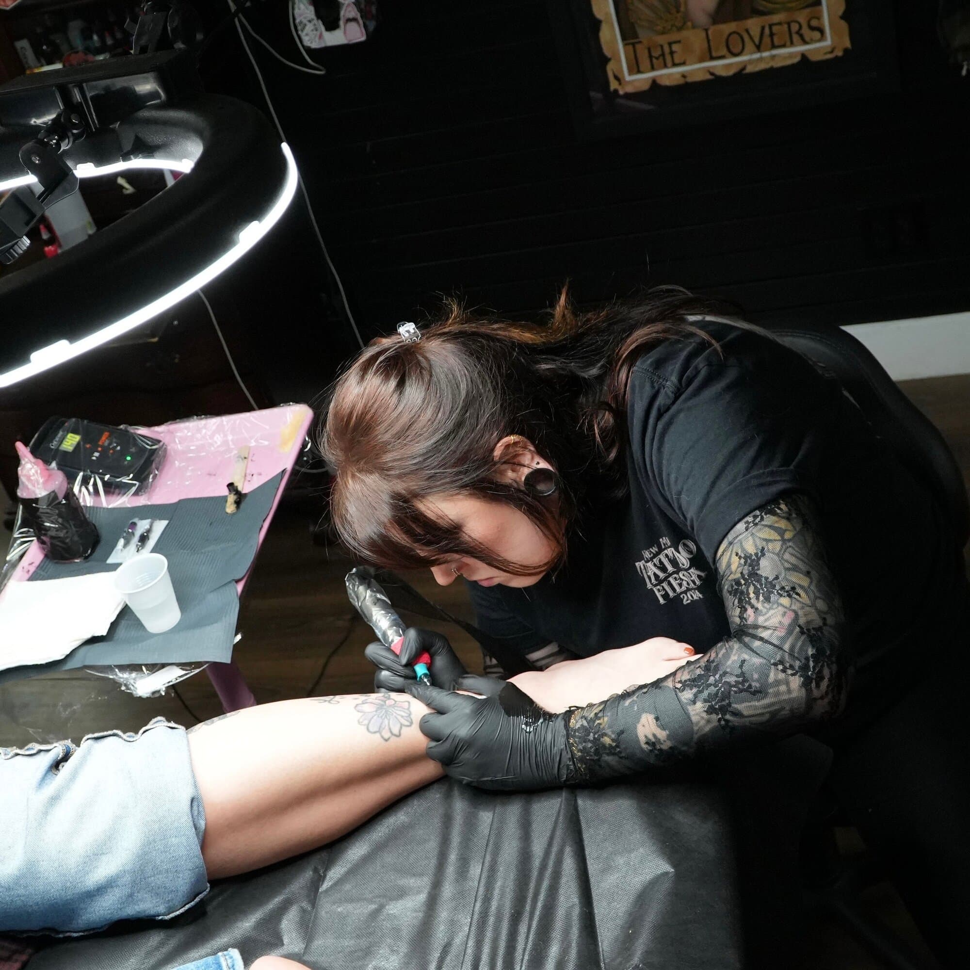 Shannon Vagott tattooing a floral piece on a client's forearm