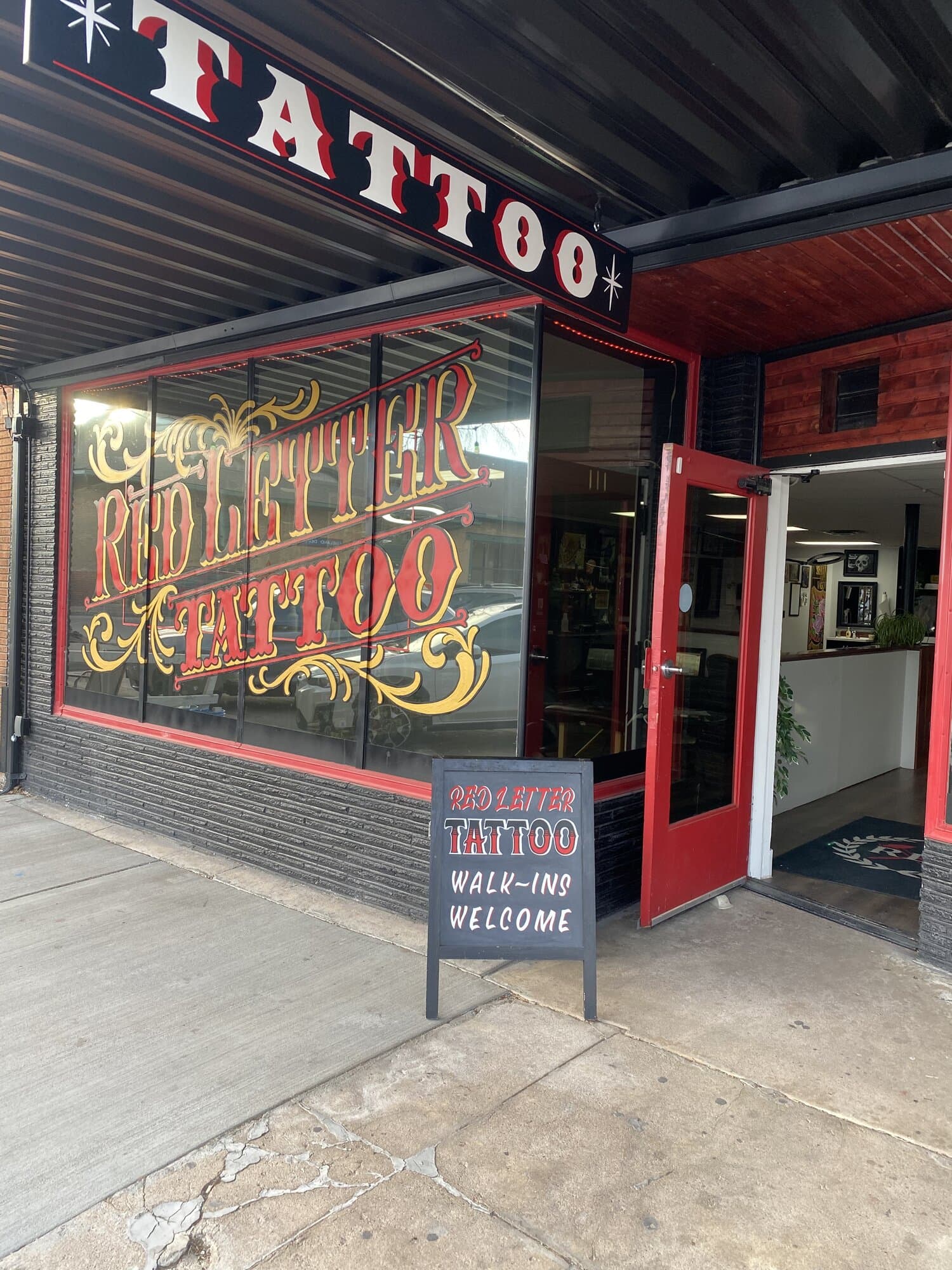 Red Letter Tattoo entrance on Fifth Street with the door open and the walk-ins welcome sign out