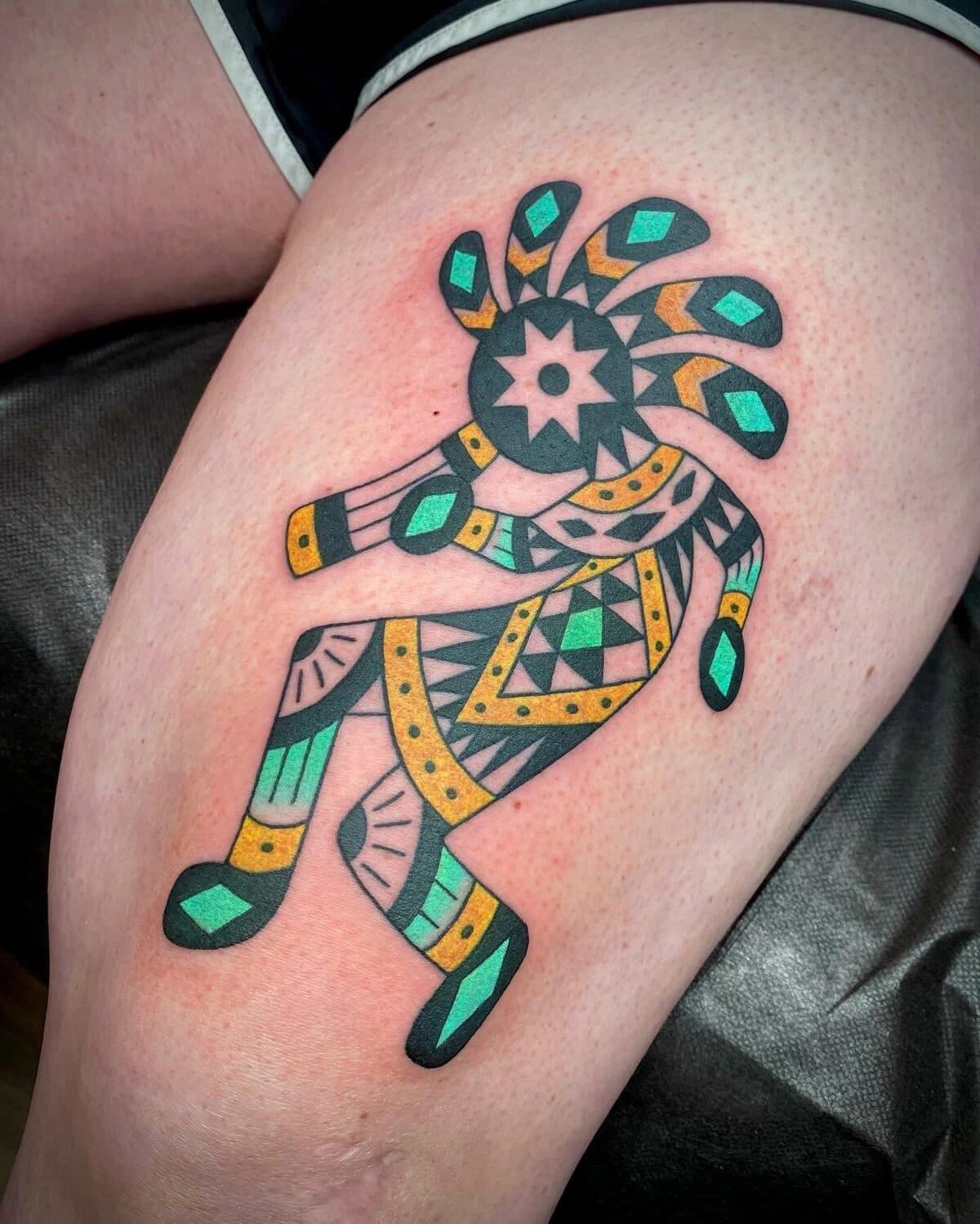 Colorful geometric Kokopelli figure tattoo
