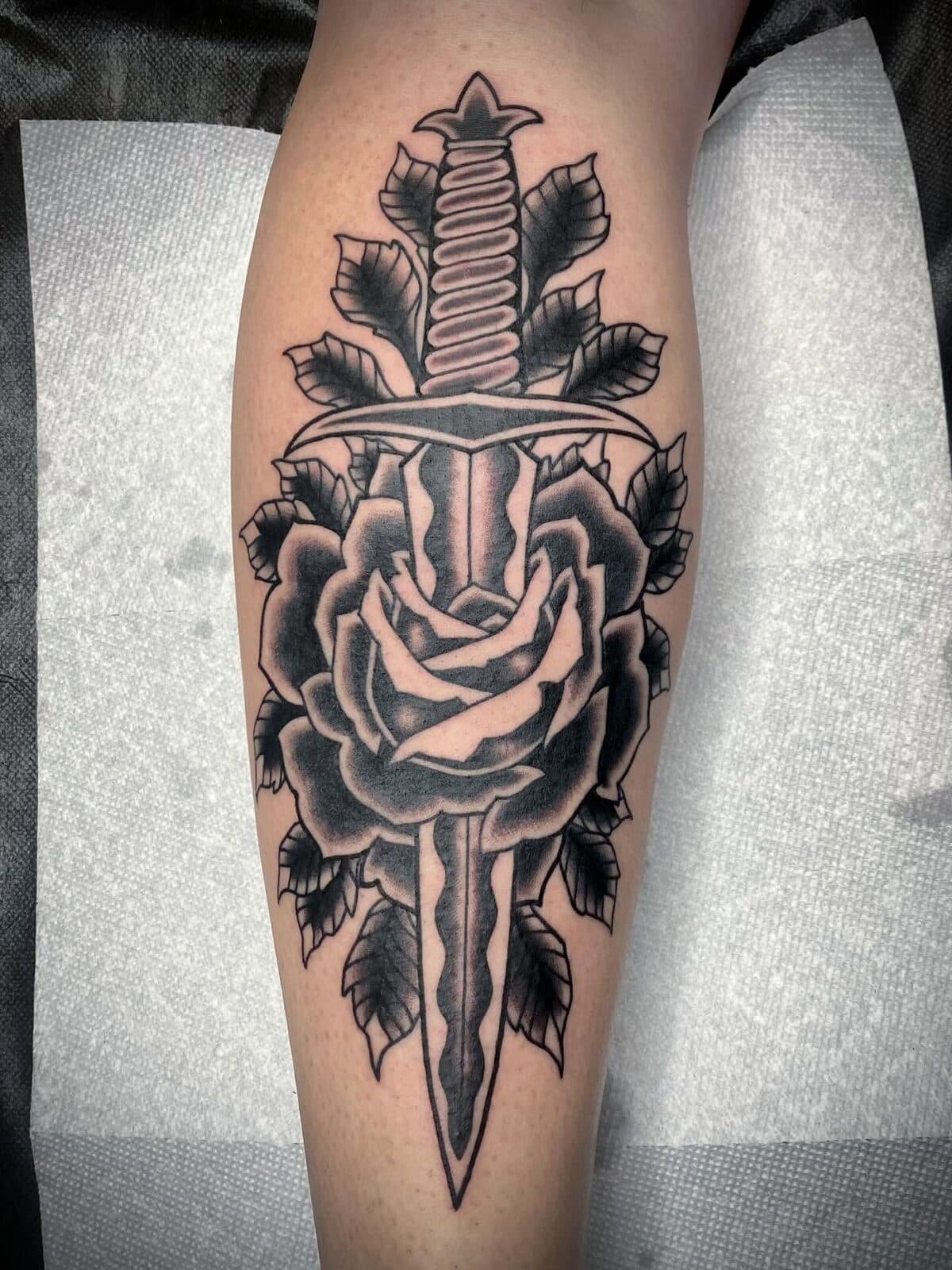 Black and gray rose with sword tattoo